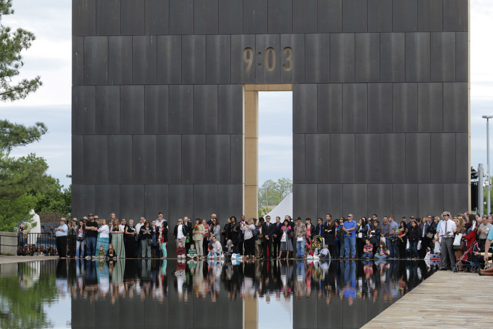 People gather at the end of the reflecting pool near the 9:03 Gate during a remembrance ceremony Sunday at the Oklahoma City National Memorial & Museum in Oklahoma City. Twenty years ago, a terrorist bombing there killed 168 people and injured many others.