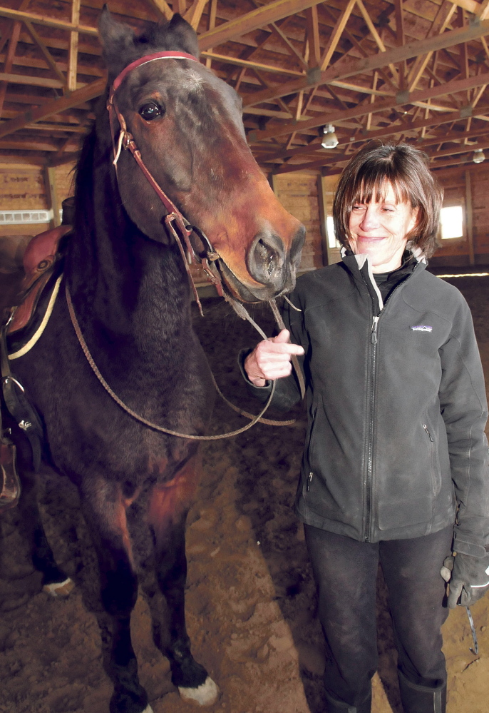 Debbie Hight stands with Postcard Jack, who has retired from harness racing and is training to be a saddle horse.