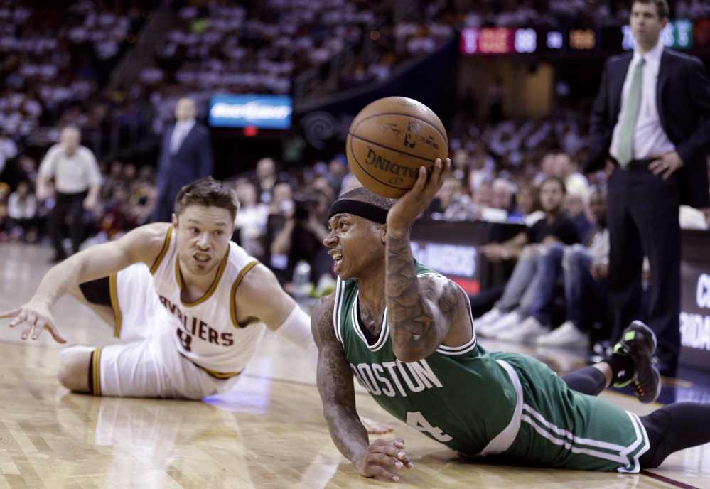 Isaiah Thomas of the Celtics looks for an open teammate after a collision with Cleveland’s Matthew Dellavedova. Thomas led Boston with 22 points. The Associated Press