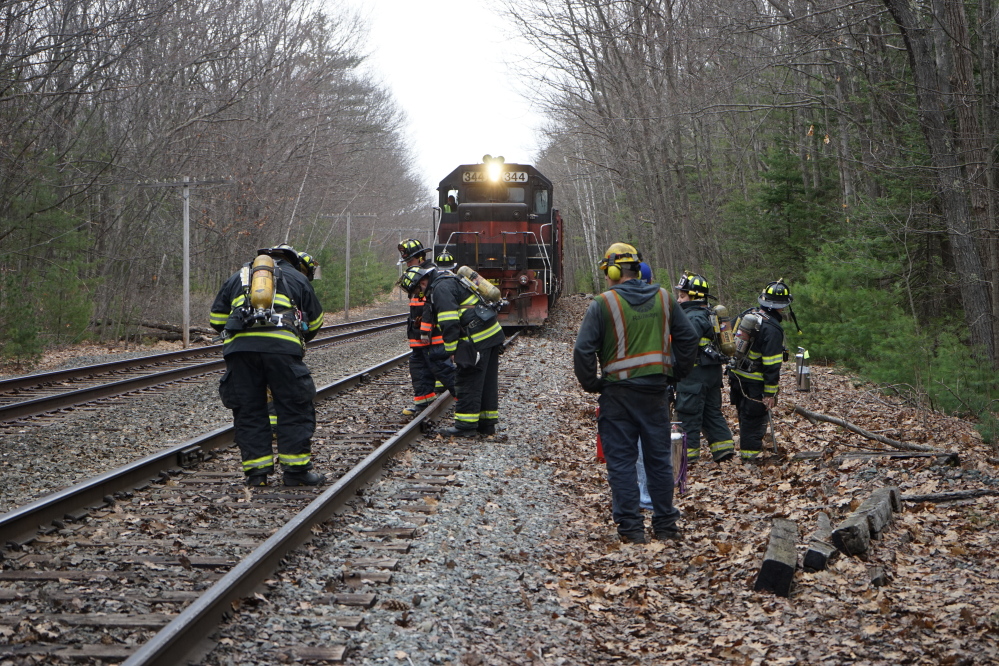 Scarborough firefighters and Pan Am Railways crew members inspect the railway off Chamberlain Road in Scarborough around 1:40 p.m. Monday.