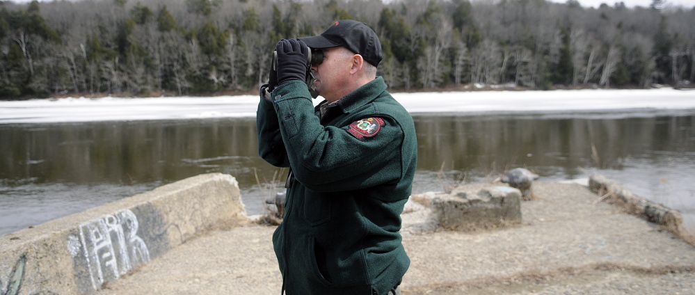 Marine Patrol Officer Clint Thompson scans the Kennebec River in Hallowell April 8 while searching for the remains of Kelly Voytasko, 54, of Augusta, who reportedly went under the ice in Augusta on March 21.