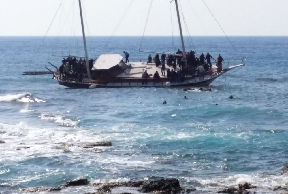 Migrants swim to reach the shore as others remain on a listing vessel that later sank in the Aegean sea near the island of Rhodes, Greece on Monday.