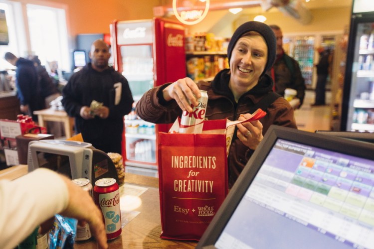 Morgan McCormack places soda into a reusable bag at Hilltop Superette on Congress Street on Monday. McCormack says she brought reusable bags to the store prior to the city’s new policy, but the new fee is “definitely a reminder.”
