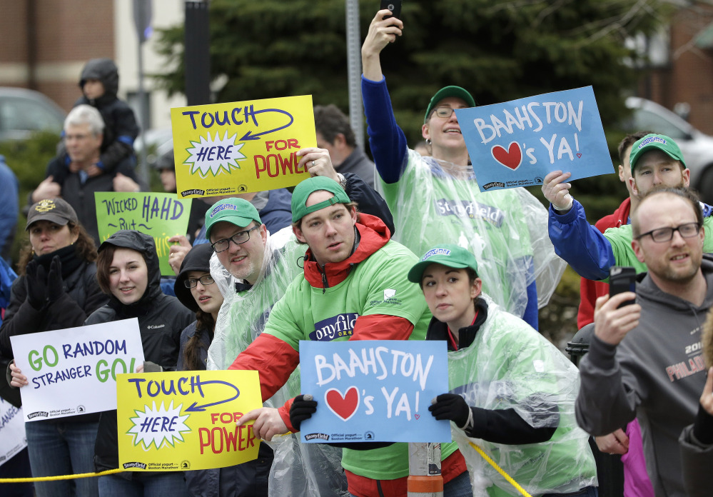 Spectators in Natick, Mass., display placards to runners in the Boston Marathon.