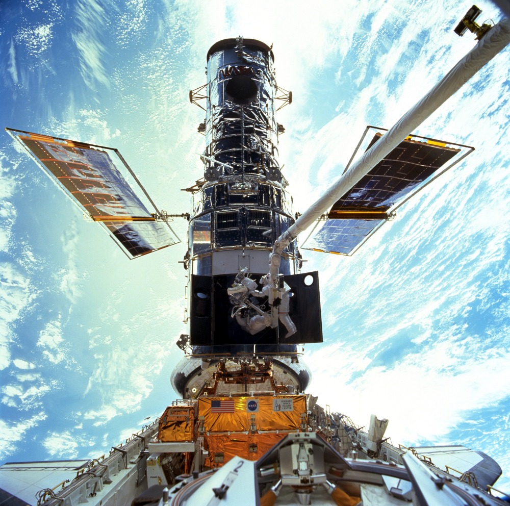 Astronauts Steven L. Smith and John M. Grunsfeld work on the Hubble during a servicing mission in 1999. NASA marks the orbiting telescope’s 25th anniversary on Friday.
