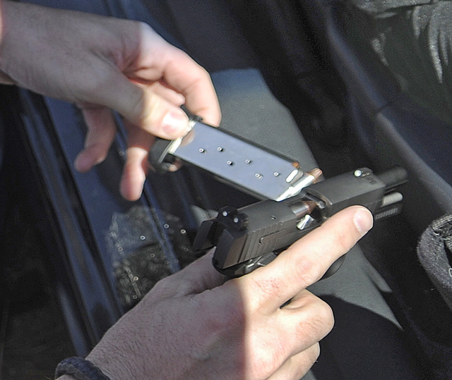 State Trooper Chris Rogers unloads a pistol recovered Wednesday from a vehicle he stopped on Interstate 95 in West Gardiner after two men reported having a gun drawn on them while traveling in the southbound lane.