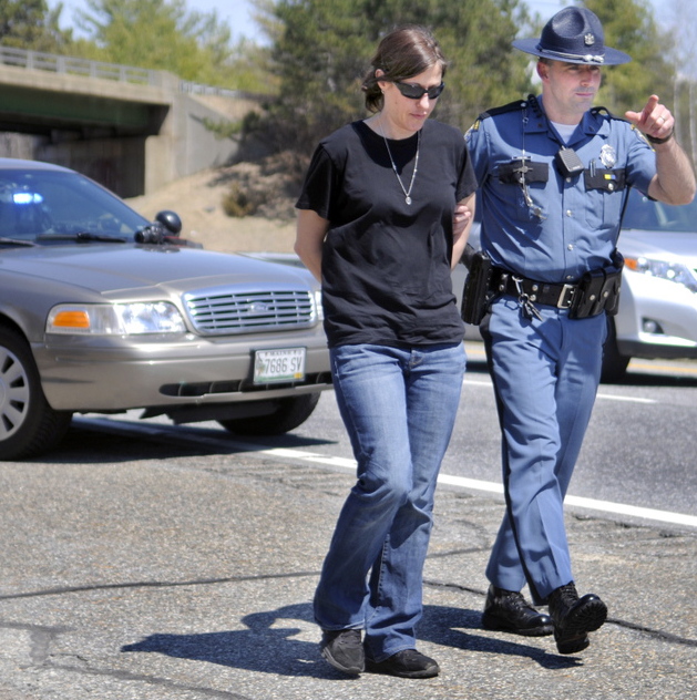 Demitria Buhalis is led to a cruiser by Maine State Police Sgt. Patrick Hood after her arrest Wednesday near the I-295 toll plaza in West Gardiner.