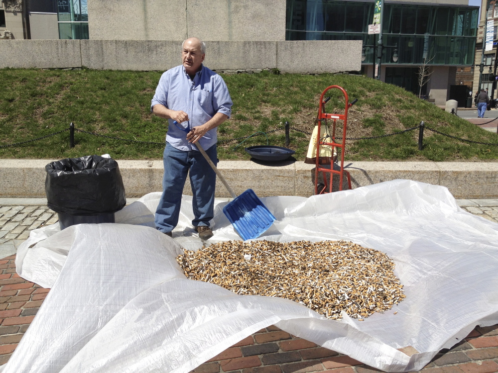 Mike Roylos, owner of the Spartan Grill, shows a pile of cigarette butts that were collected in SideWalk Buttler receptacles in Monument Square in Portland. Roylos held the demonstration on Earth Day to call attention to local clean-up efforts.