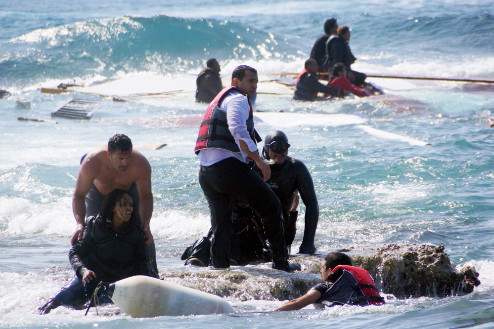 Migrants seek safety in the Aegean Sea island of Rhodes on Monday after their wooden boat sank, killing at least three people, including a child.