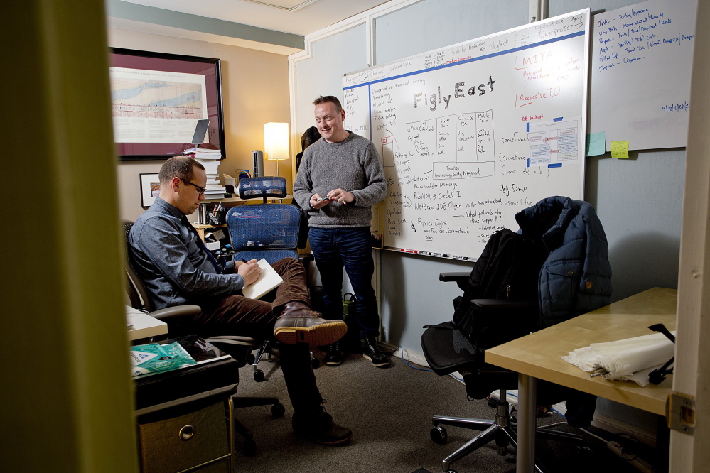 Elliot Murphy, right, who works for a San Francisco-based startup, and Abe Fettig, a senior architect, confer in their office space at Think Tank in downtown Portland. Murphy took his high-tech job with him to Portland when he moved here from Florida.