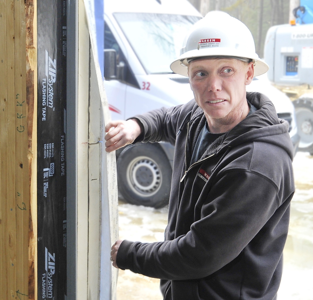 Mike Matthes, supervisor for Warren Construction Group, shows the six layers of material that create an airtight barrier in the walls of the new Friends School of Portland.