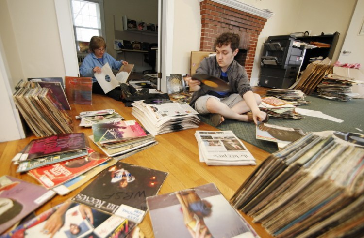 Zach Lapierre, right, a freshman at the University of Southern Maine and a work-study student at WMPG, and Jessica Lockhart, a WMPG volunteer who teaches radio production, help to stack record albums in newspaper after a broken water pipe caused a flood in its studios Wednesday night in Portland.