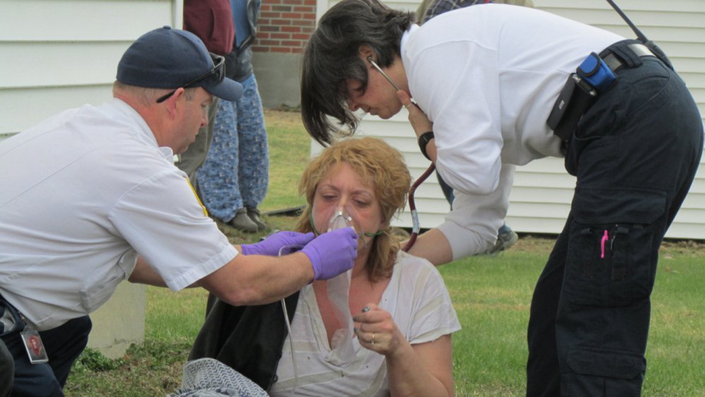 Christie Mann is treated for possible smoke inhalation after being pulled to safety from her Winslow apartment Thursday.