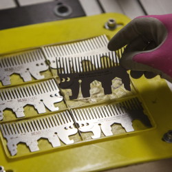 Freshly etched Headgehog multi-tools, each the size of a credit card, are inspected at Zootility Tools’ Portland facility. The Headgehog small steel comb also serves as a wrench, bottle opener, phone kickstand and chip clip. Carl D. Walsh/Staff Photographer