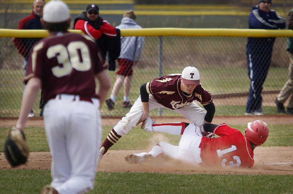 Thornton Academy third baseman Mitch Jacques tags out South Portland’s Henry Curran on a stolen-base attempt.
