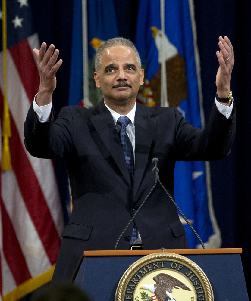 Attorney General Eric Holder acknowledges  applause of Justice Department employees as he ends his farewell speech in Washington on Friday.