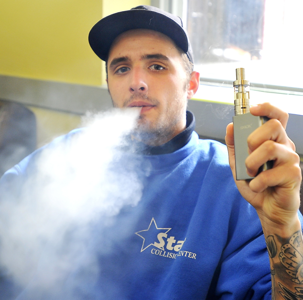 Richard Gadourey uses his vaporizer in the Old Port Vape Shop on Market Street. Portland is evaluating an ordinance that treats vaporizers like cigarettes.