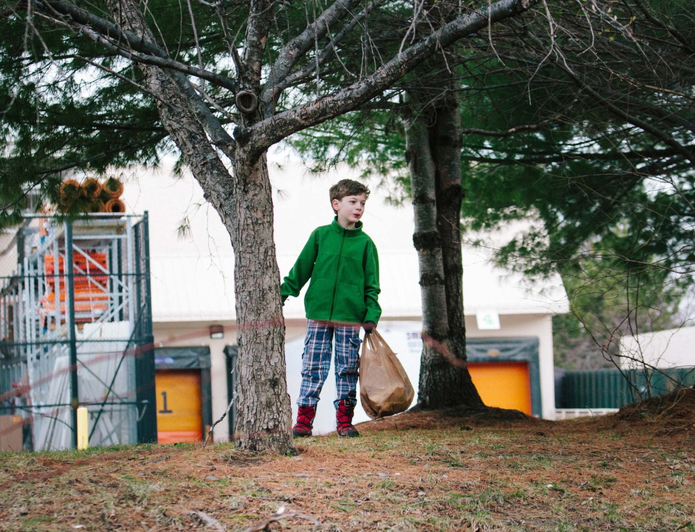 Rocco Sullivan, 8, picks up trash in the area around Clark Pond behind Home Depot with his brothers’ Boy Scout troop in South Portland on Saturday.