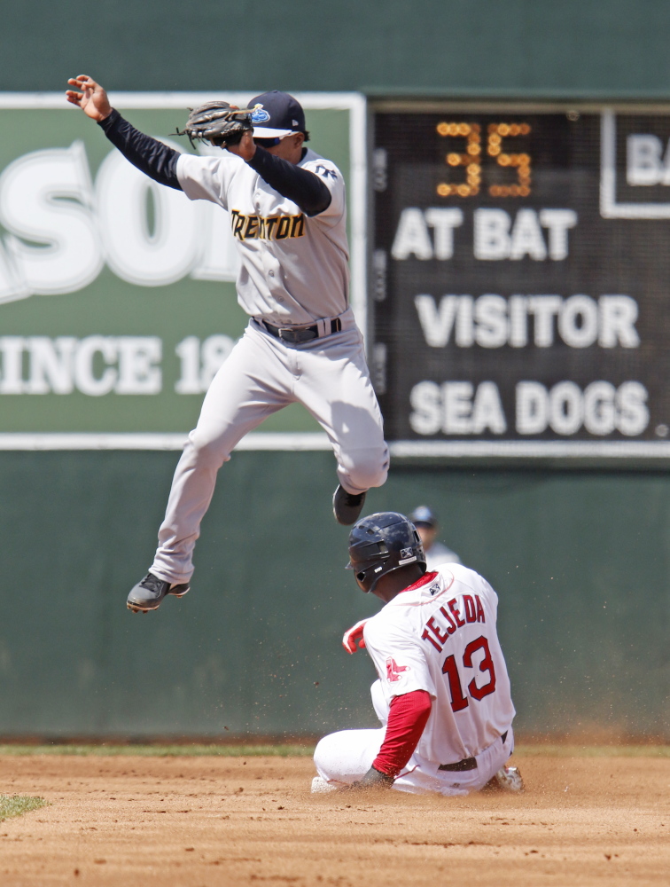 Oscar Tejeda of the Portland Sea Dogs slides safely into second base with a steal Saturday as Jose Rosario of the Trenton Thunder leaps for the catch during the second inning of the Sea Dogs’ 7-3 victory at Hadlock Field.