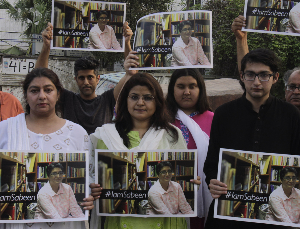 Members of the social group “Umeed Jawan Peace Society” hold pictures of Sabeen Mahmud, who was killed Friday by unknown gunmen.