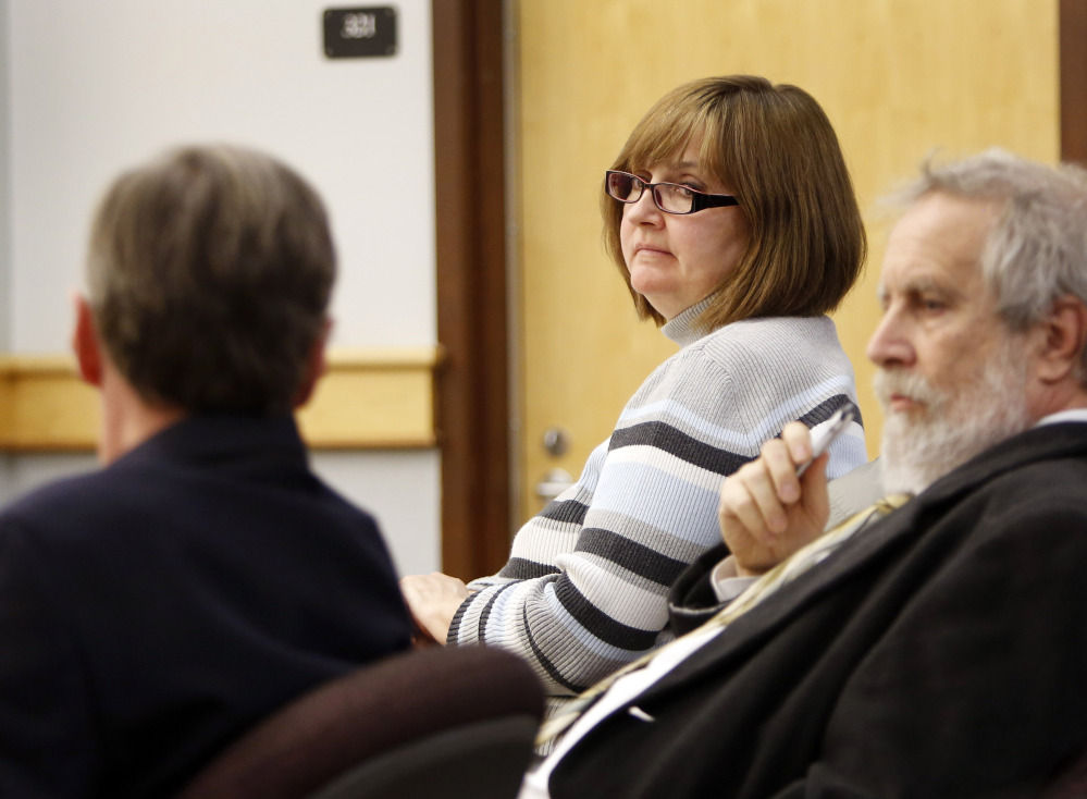 Genevieve Kelley, center, looks back at her lawyers during a hearing in Coos County Superior Court in Lancaster, N.H. Kelley is charged with fleeing the country with her young daughter during a custody dispute.