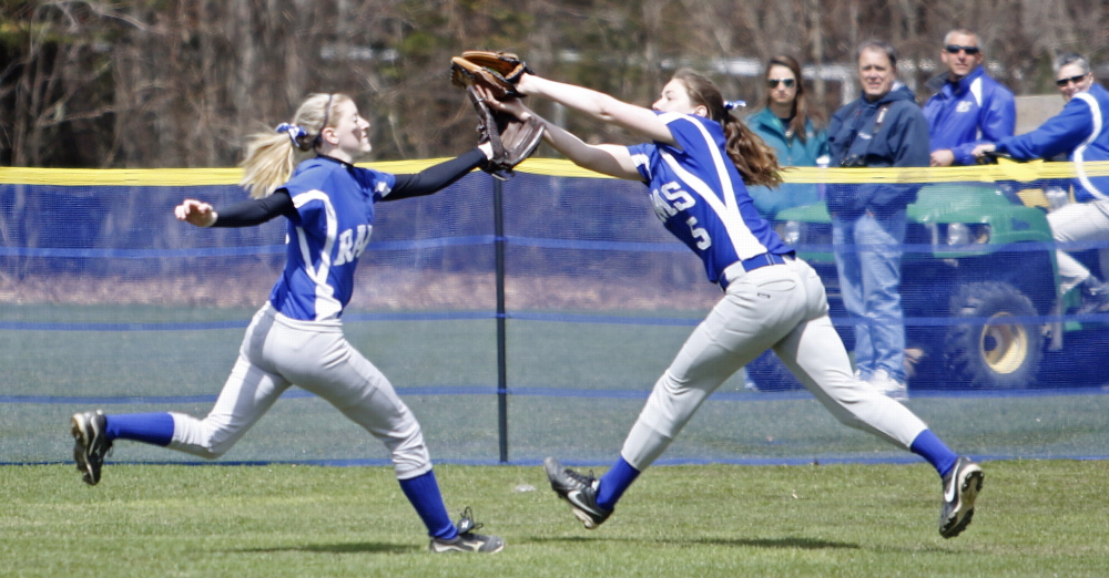 Kennebunk center fielder Hayley Morais, left, and right fielder Kylie Defeo chase a fly ball that was caught by Defeo during Saturday’s softball game against Cape Elizabeth, which won 10-9 in extra innings.