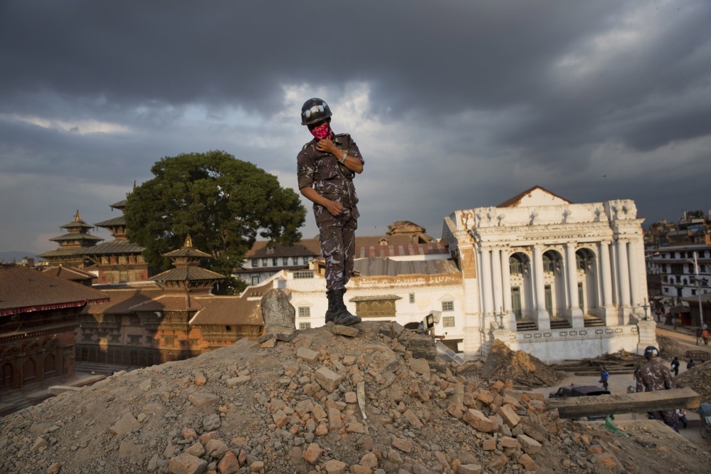 A Nepalese policeman stands atop of a rubble at Basantapur Durbar Square on Sunday that was damaged in Saturday’s earthquake in Kathmandu, Nepal.