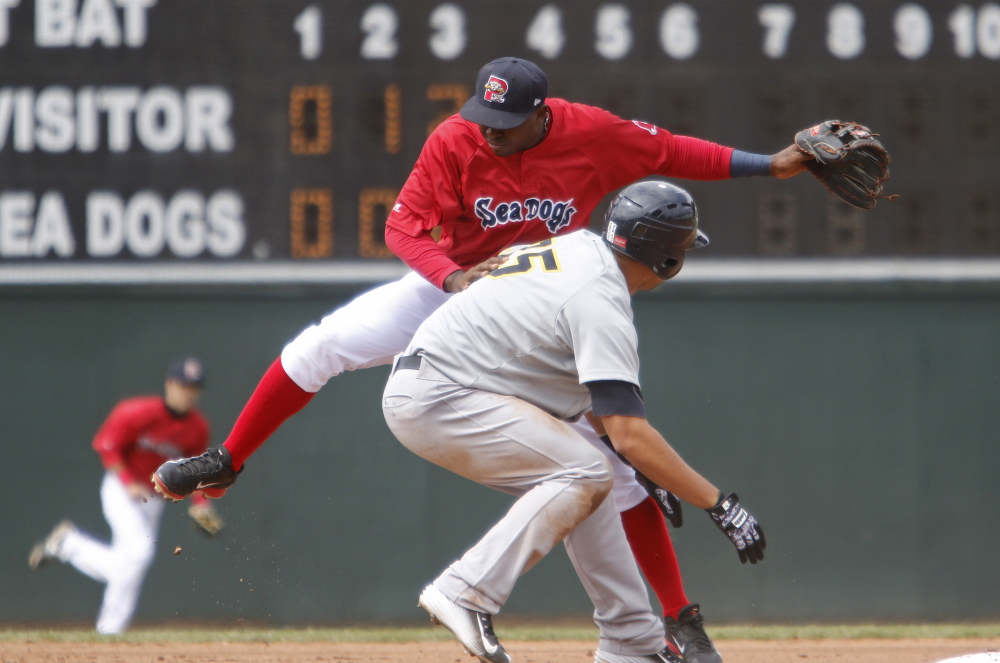 Sea Dogs shortstop Oscar Tejeda gets caught up with Trenton catcher Gary Sanchez at second base in the fourth inning at Hadlock Field in Portland on Sunday.