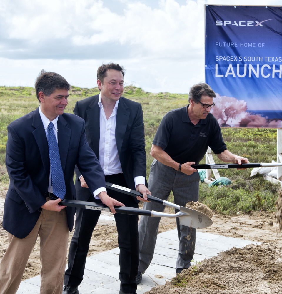 Texas Rep. Filemon Vela, left, SpaceX founder and CEO Elon Musk, center, and Texas Gov. Rick Perry turn the first shovels of sand at the groundbreaking ceremony for the SpaceX launch pad at Boca Chica Beach, Texas, in 2014.