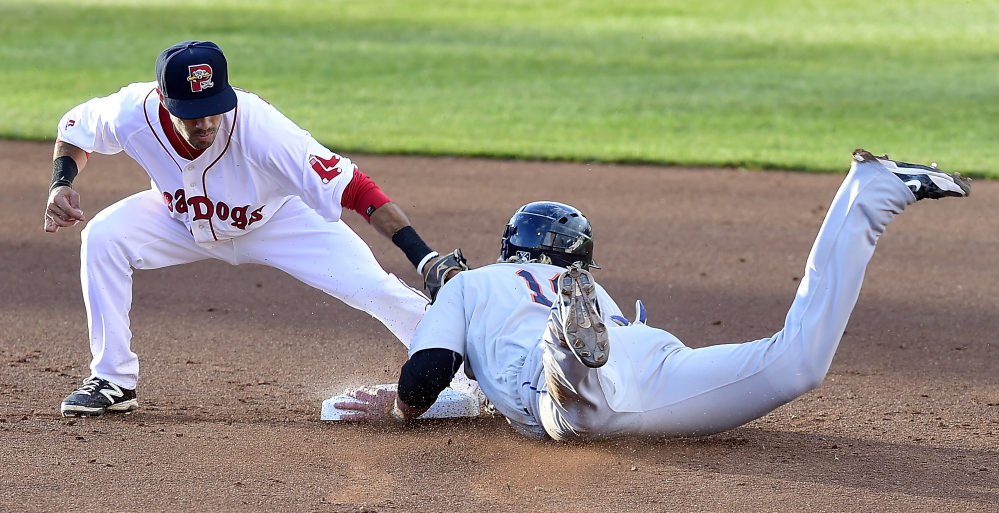 The Mets' Dustin Lawley slides safely into second on a steal as Sea Dog Carlos Asuaje makes the late tag Monday night. The game resumed Tuesday and the Mets won. The teams are playing a second, 7-inning game Tuesday night. (Photo by Gordon Chibroski/Staff Photographer)