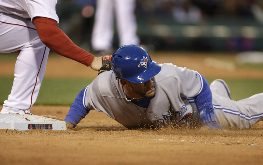 Toronto Blue Jays' Devon Travis, right, jumps back to first base to survive a pick-off attempt in the fourth inning as Boston's Daniel Nava tries to tag him. (AP Photo/Steven Senne)