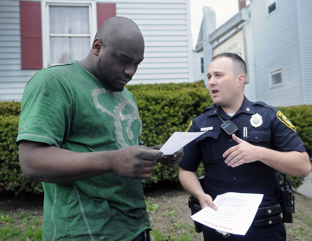 Augusta Police Officer Jesse Brann speaks with Water Street resident Breon Shannon on Wednesday while handing out fliers to notify people of a larger police presence planned. Shannon said he sees a lot of drug-related crime in the neighborhood. Police spread out across Augusta to hand out the information while soliciting input on how to combat crime.
