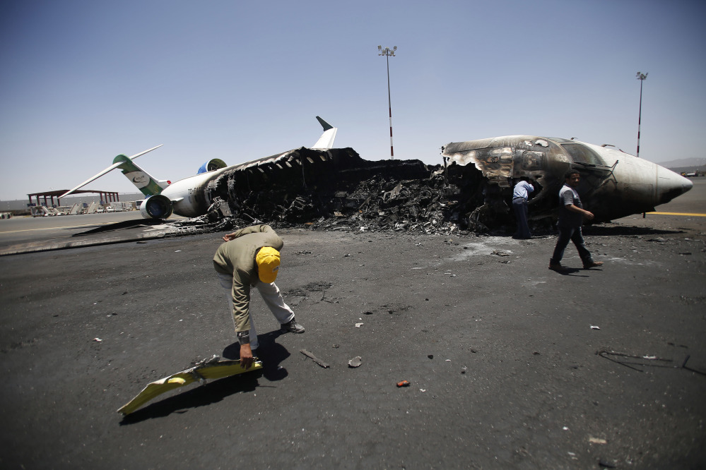 Officials of Felix Airways, a domestic airline, inspect a plane destroyed by Saudi-led airstrikes, at the Sanaa International Airport, in Yemen, on Wednesday. Saudi-led coalition warplanes pounded Shiite rebels and their allies overnight and throughout the day on Tuesday in the Yemeni capital. Around midday, airstrikes hit Sanaa International airport, setting a plane owned by a private company on fire, according to a statement released by the Houthis.