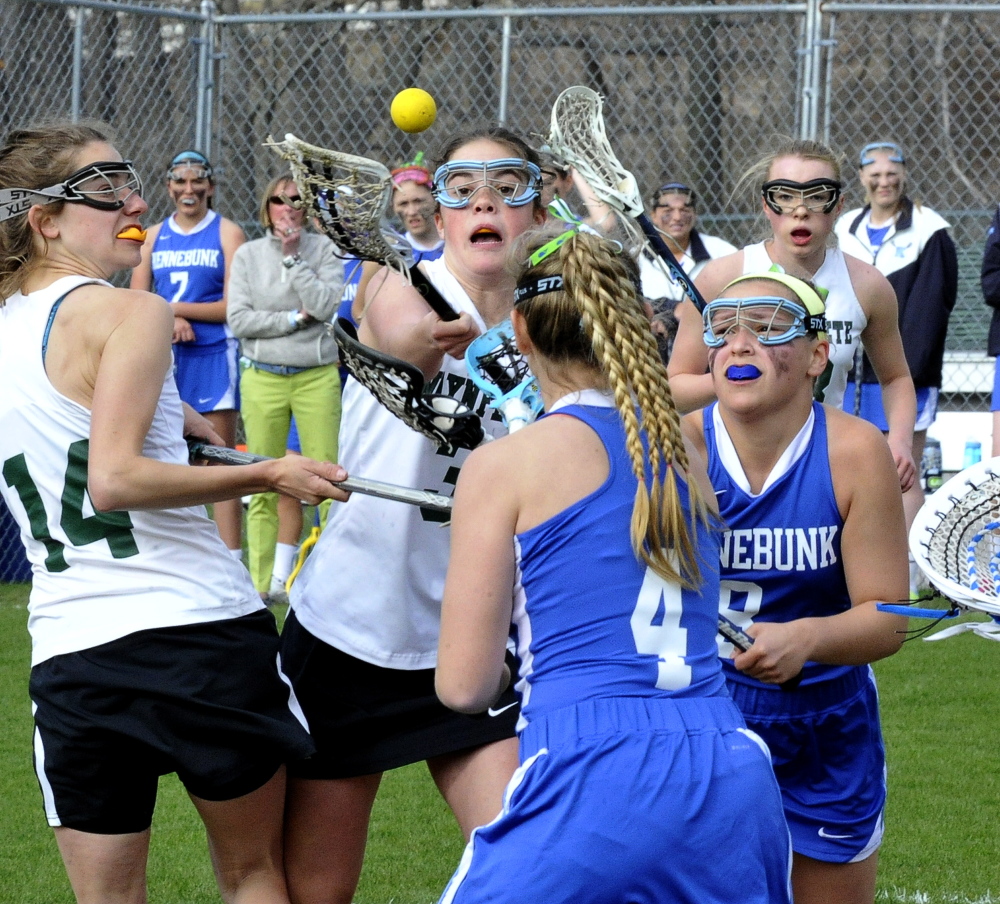 Waynflete’s Christian Rowe, center, vies for the ball against  Kennebunk’s Molly Parent, front right, and Hannah Pepin.