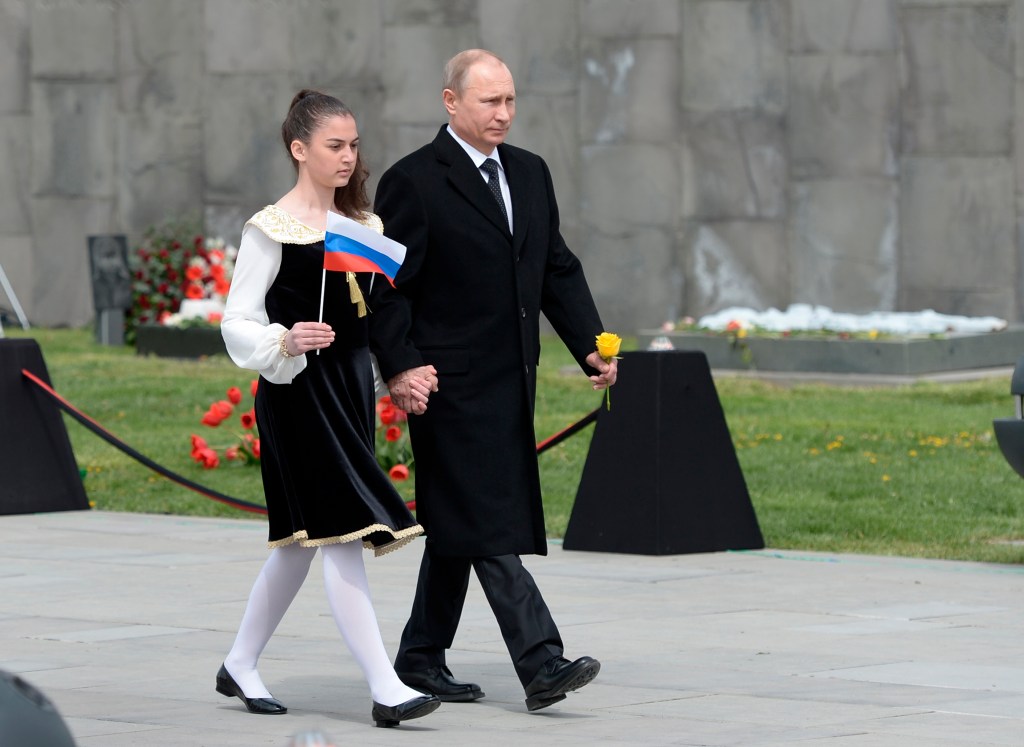 Russian President Vladimir Putin, escorted by a girl holding a Russian flag, walks at the Tsitsernakaberd Armenian Genocide memorial complex in Yerevan, Armenia, Friday. He is among world leaders attending ceremonies commemorating the massacre of Armenians by Ottoman Turks. The Associated Press