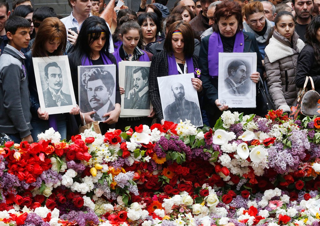 People lay flowers at a memorial to Armenians killed by the Ottoman Turks, as they mark the centenary of the mass killings, in Yerevan, Armenia, Friday. The Associated Press