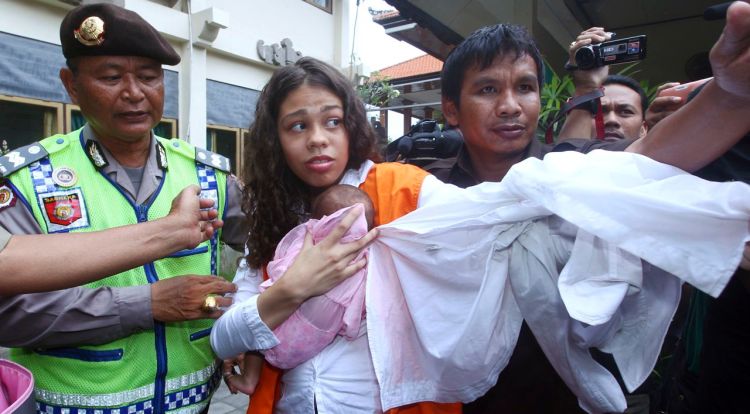 Heather Mack of Chicago carries her baby daughter as she arrives at the Denpasar District Court before the verdict was read Tuesday in her trial in Bali, Indonesia. The Associated Press