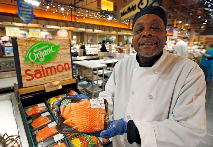 Cooking coach and chef Charles Hill holds a Canadian certified organic farm-raised King Salmon at the Wegmans, in Fairfax, Va., on Friday. The Associated Press