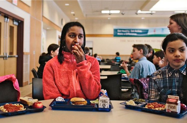 Shurube Stamey, a fifth-grader at Westbrook Middle School, enjoys a piece of fruit at lunchtime. Whitney Hayward / Staff Photographer
