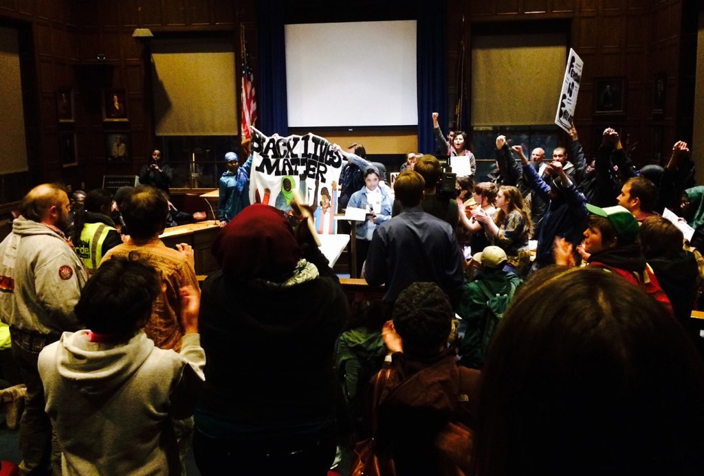 Protesters chant "black lives matter" while occupying the council chambers at Portland City Hall on Thursday night. Erin Hennessy, seen speaking in the center, said, "I've rubbed my eyes red. How many more Michael Browns? How many more Trayvon Martins? .... We need a new definition of justice."