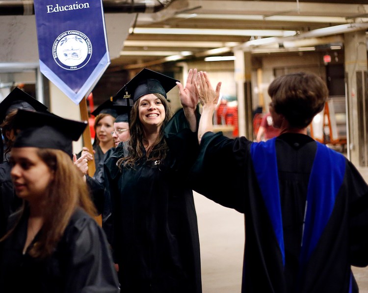 Patty Hall, an early childhood education student gives a high-five to her professor Rachel Parse as she enters Cross Insurance Center for the Southern Maine Community College graduation. Derek Davis/Staff Photographer