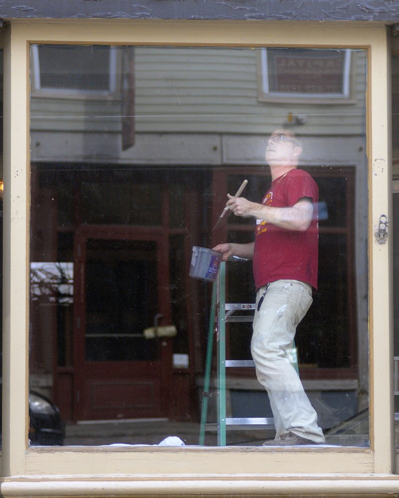 Chris Vallee paints trim inside the windows of a building he’s renovating on Water Street in Hallowell in this April file photo. The Quarry Tap Room should be open by May, Vallee said, and offer a selection of up to 30 beers. Vallee and his business partner, Steven Lachance, plan to operate the bar as a hobby, Vallee said. Andy Molloy/Kennebec Journal