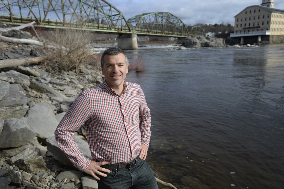 Jeremy Bell of The Nature Conservancy stands beside the Androscoggin River in Brunswick. He dreams of seeing wild Atlantic salmon there.