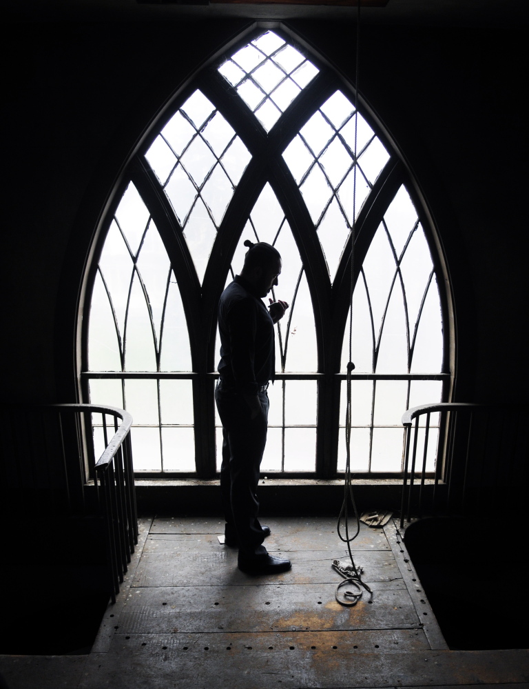 David Boucher stands in the bell tower while phoning to set up Internet service for his tasting room. Many of  the church pews and the large pipe organ will remain.