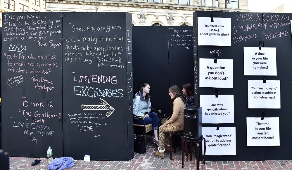 Kelsey Bubar, a social work student at the University of Southern Maine listens to Karen Thuotte, right, and her daughter, Aleah, 10, in a listening wall put up by the professors and students.