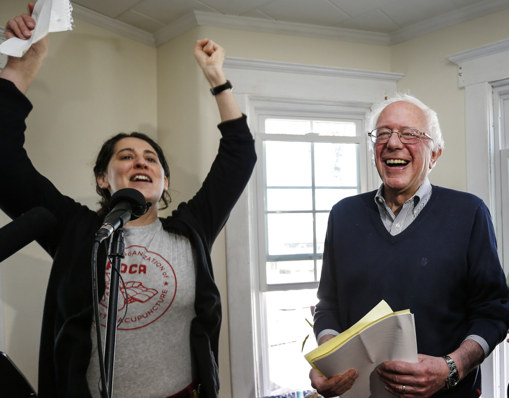 Presidential hopeful Sen. Bernie Sanders, right, greets more than 100 cheering supporters before speaking at a house party in Manchester, N.H., Saturday.