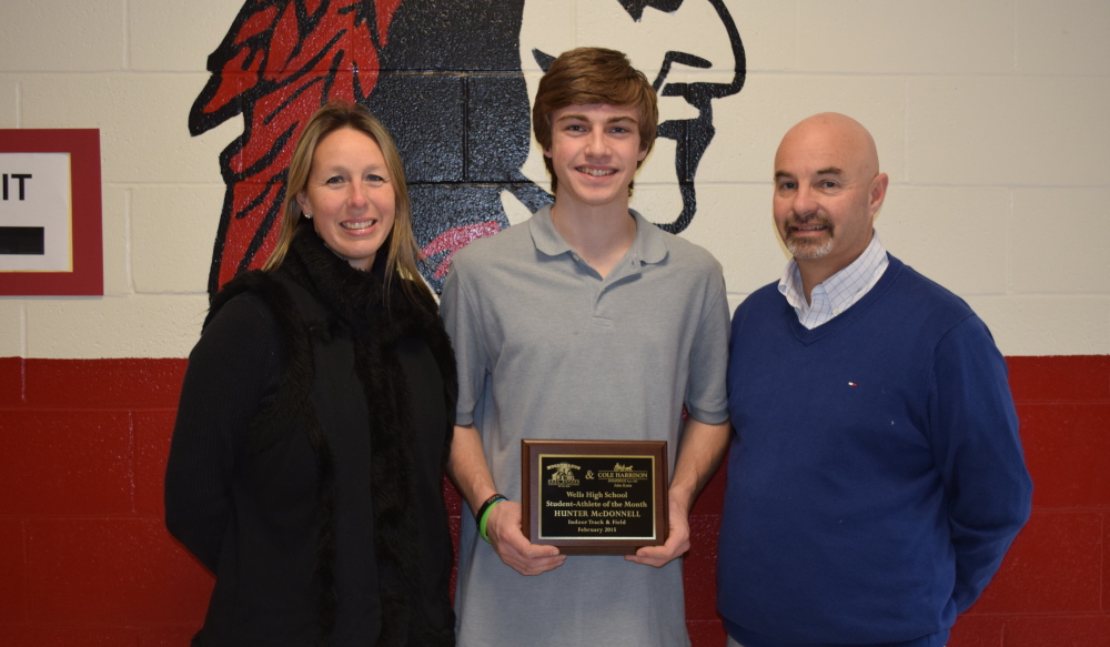 Hunter McDonnell, center, a Wells High School senior, is presented the Student-Athlete of the Month Award by Pamela Moody-Maxon and Activities Director Jack Molloy.