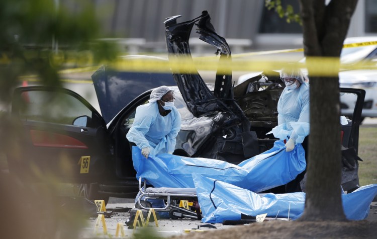 Personnel remove the bodies of two gunmen Monday, in Garland, Texas.