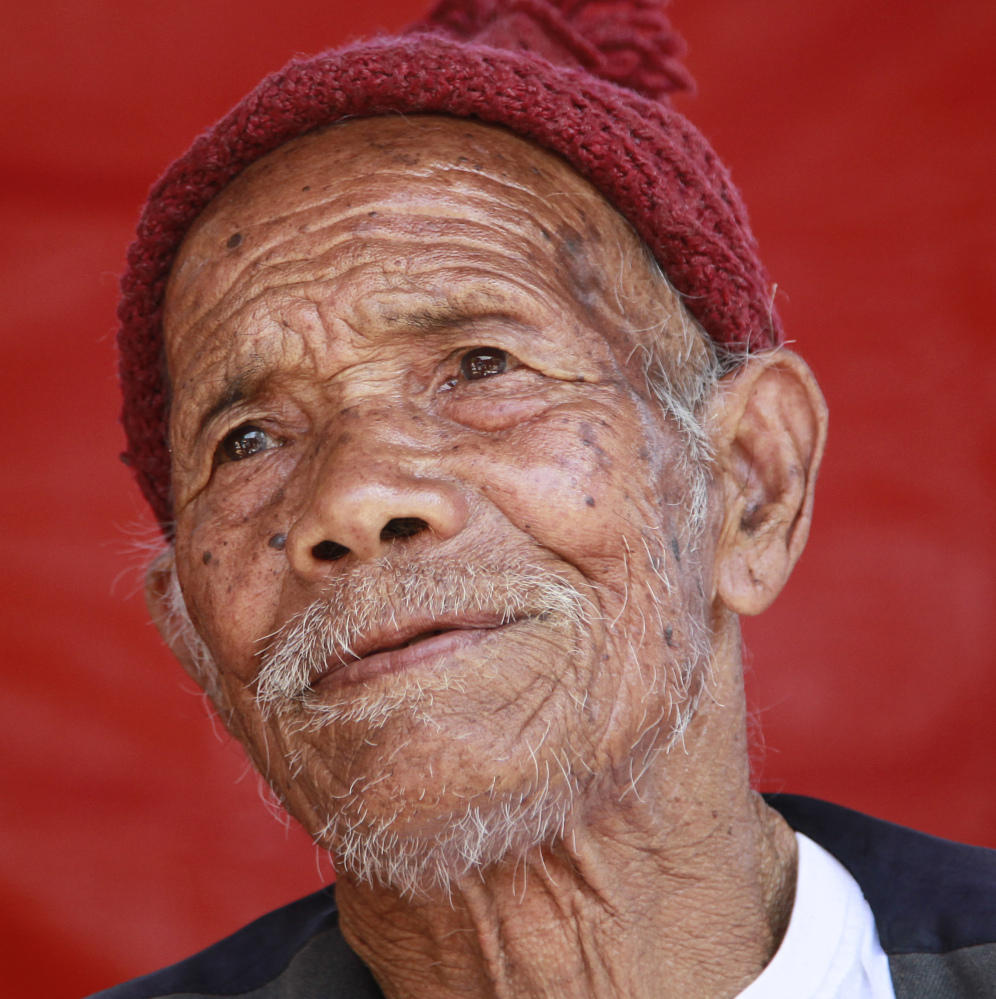 Funchu Tamang, who believes himself to be 101 years old, sits at a makeshift hospital in Bidur, Nuwakot District, Nepal, on Monday. By his own account, he should have died. But when the humble hut of stacked stones collapsed onto Funchu Tamang, his daughter-in-law quickly pulled him from the wreckage.
