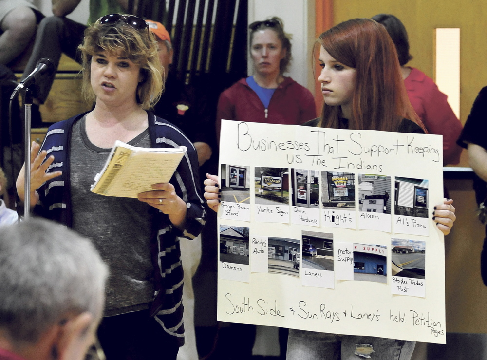 Nicole Carter, left, speaks in support of the continued use of “Indians” for SAD 54 sports teams as Bailey Keister holds a sign of support during a forum in Skowhegan on Monday.